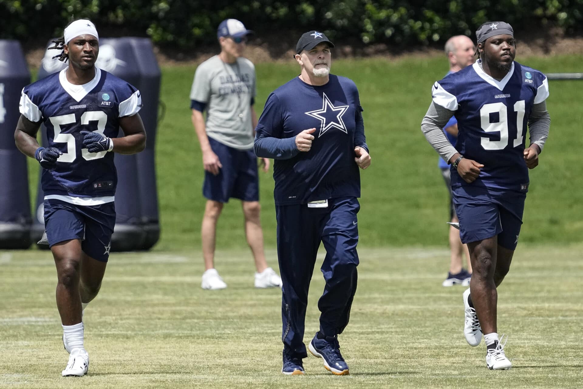 Dallas Cowboys undrafted free agent linebacker Isaiah Land (53), defensive coordinator Dan Quinn (C), and undrafted free agent defensive end Tyrus Wheat (91) participate in the NFL football team's rookie minicamp in Frisco, Texas, Saturday, May 13, 2023. (AP Photo/Sam Hodde)